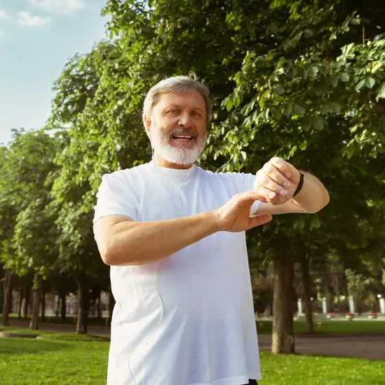 An older man checking his watch on a morning walk, the active everyday routine MemoHoney is aimed at